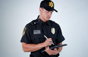 Professional security guard in uniform using a tablet during emergency response training to demonstrate crisis preparedness and rapid decision-making skills
