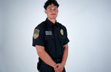 Professional security guard in uniform standing confidently against a neutral background, representing high-quality customer service from Los Angeles security companies