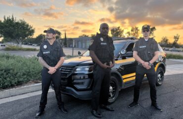 Alert security guard in uniform scanning surroundings outside a building, highlighting visible deterrence and common vulnerabilities criminals look for