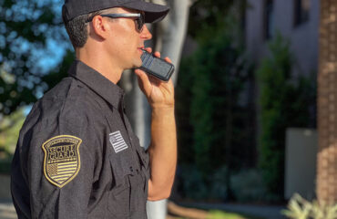 Security guard communicating via radio during an emergency response, demonstrating real-time coordination and professional security team actions