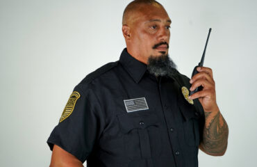 Professional security guard using two-way radio, representing trusted security guard services for businesses in Los Angeles